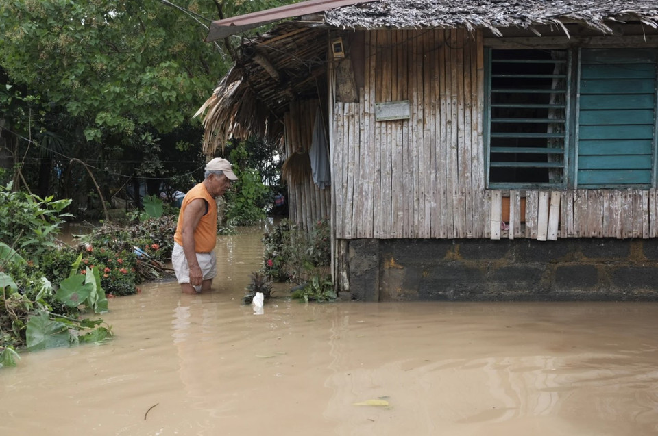 Người dân lội trong nước lũ ở Polangui, tỉnh Albay (Philippines), ngày 23/10/2024. (Nguồn: AP)