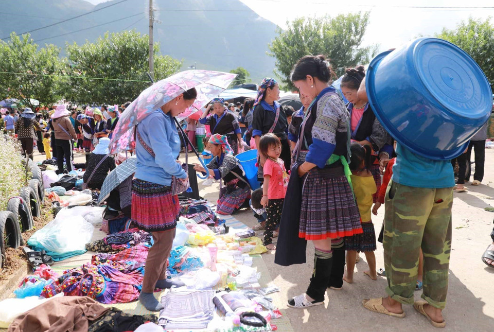 Càng về gần trưa, chợ càng đông đúc và nhộn nhịp với những chiếc váy hoa rực rỡ của đồng bảo dân tộc Mông trên các rẻo cao. (Ảnh: Quý Trung/TTXVN)