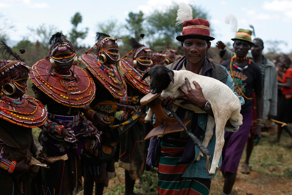 Một người đàn ông Pokot bế một con cừu đi ban phúc cho các bé gái trong lễ trưởng thành. (Ảnh: Siegfried Modola/Reuters) 