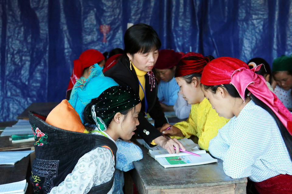 Cô giáo Vũ Thị Gấm, Giáo viên trường Tiểu học xã Sảng Tủng là người phụ trách lớp học xóa mù đang hướng dẫn học sinh học nhóm. (Ảnh: Đỗ Bình - TTXVN) 