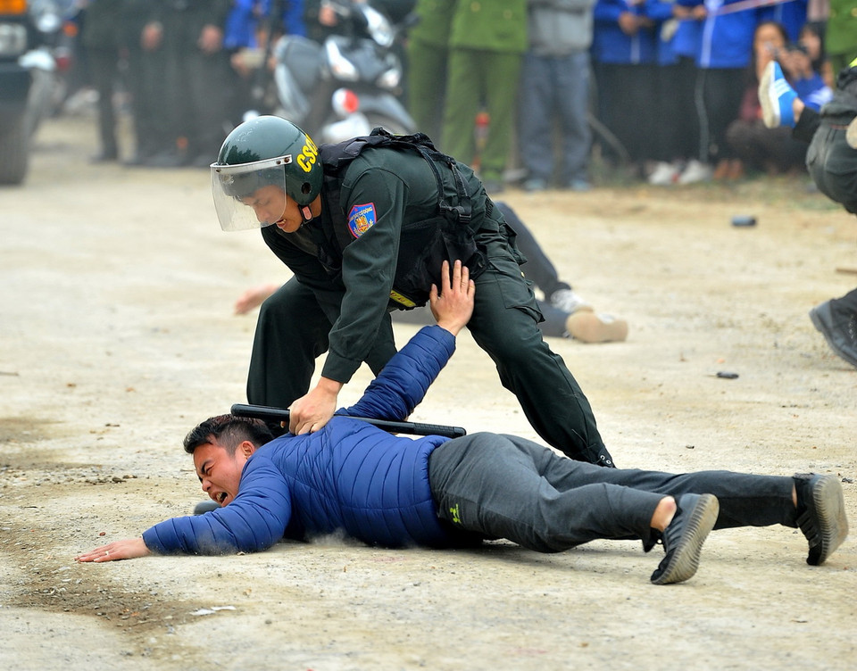 Cảnh sát cơ động khống chế các đối tượng quá khích. (Ảnh: Minh Đức/TTXVN)