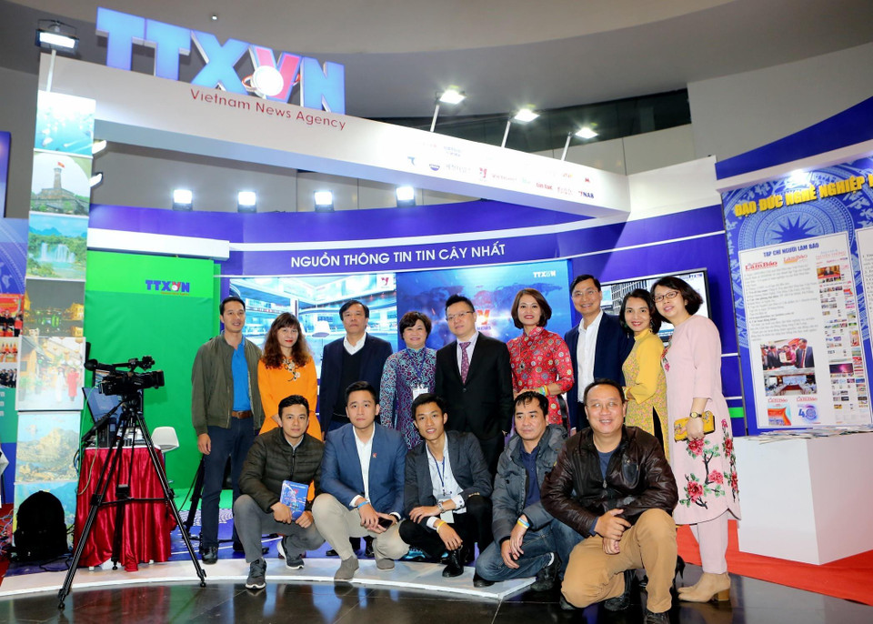 Phó Tổng Giám đốc TTXVN Lê Quốc Minh với cán bộ, phóng viên, biên tập tại gian trưng bày của Thông tấn xã Việt Nam. (Ảnh: Thành Đạt/TTXVN)