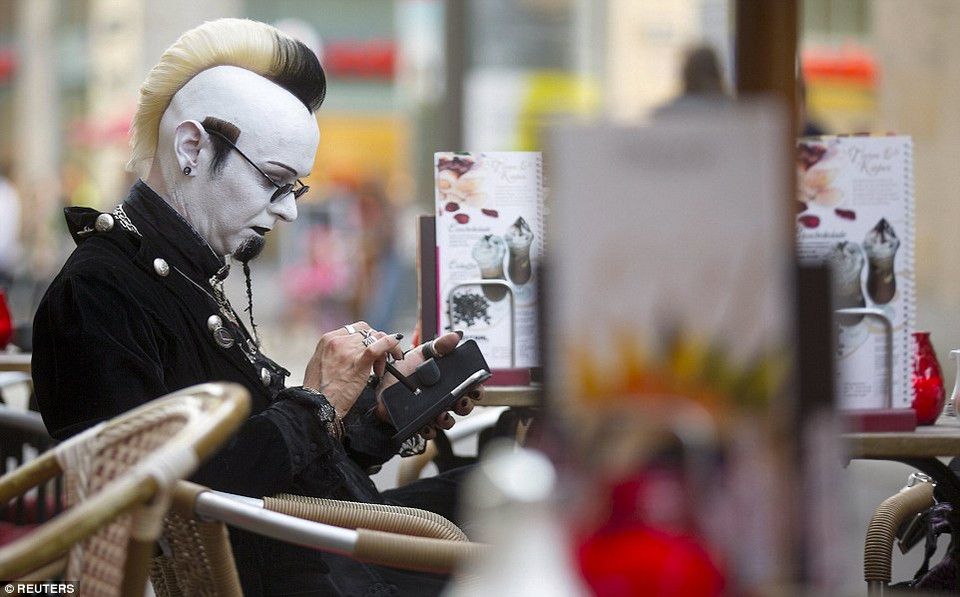 Một tín đồ văn hóa Gothic tạm nghỉ khi ngồi nghỉ ở một quán càphê để kiểm tra điện thoại. (Nguồn: dailymail.co.uk)