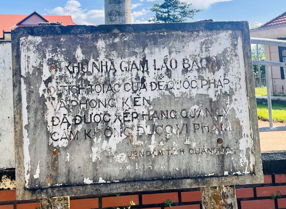 Tấm biển chỉ dẫn di tích Nhà tù Lao Bảo nham nhở, rất khó đọc. (Ảnh: Nguyên Linh/TTXVN)