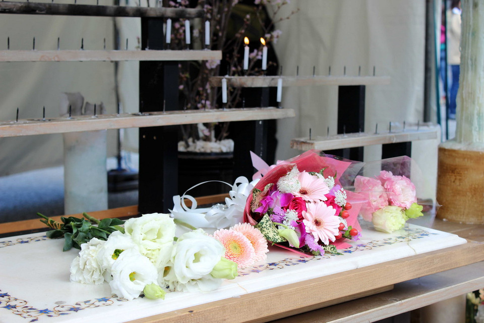 Những bó hoa tưởng niệm đầu tiên được đặt lên án. (Ảnh: Hữu Thắng/Vietnam+)