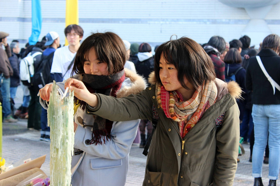 Các nữ sinh Nhật Bản thắp nến tưởng niệm. (Ảnh: Hữu Thắng/Vietnam+)