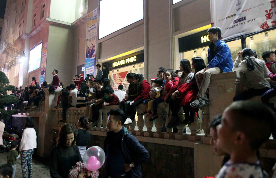 Tận dụng tối đa mọi nơi để có thể theo dõi chương trình. (Ảnh: Doãn Đức/Vietnam+)