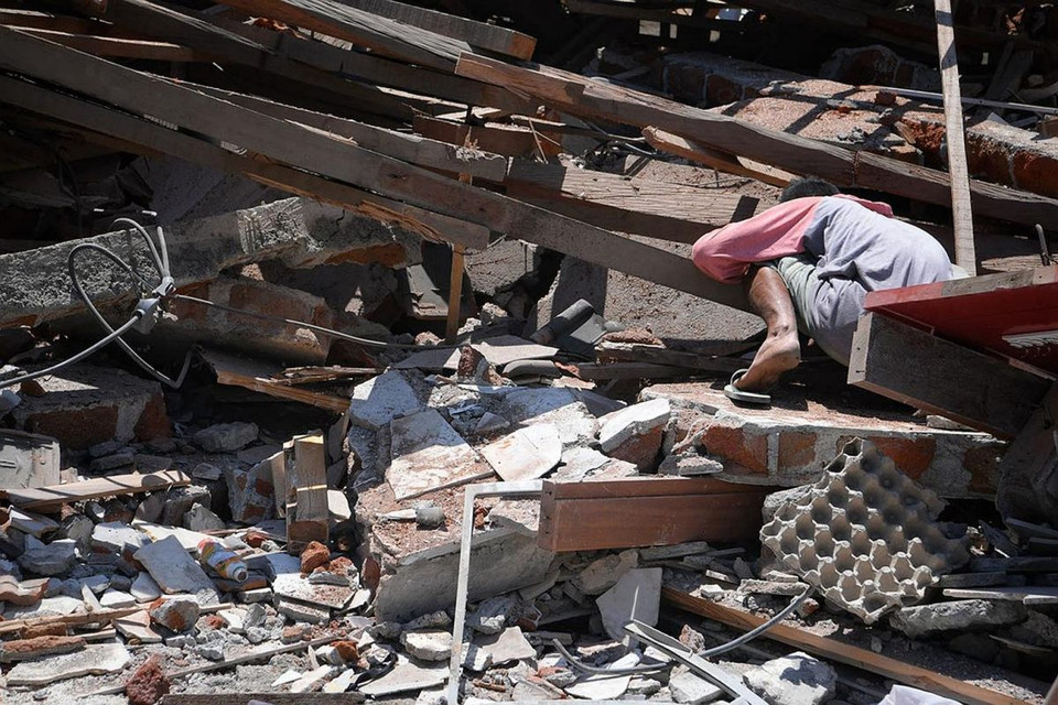 Một người dân tìm kiếm Dea Mukti, 21 tuổi, bị mắc kẹt dưới đống đổ nát ở làng Karang Montong Laut trên đảo Lombok của Indonesia, vào ngày 7/8.