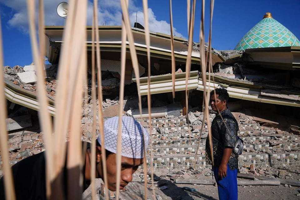 Dân làng Karang Pangsor tại nhà thờ Hồi giáo Jami'ul Jama'ah đã sụp đổ, nơi có ít nhất năm người vẫn bị mắc kẹt dưới đống đổ nát.