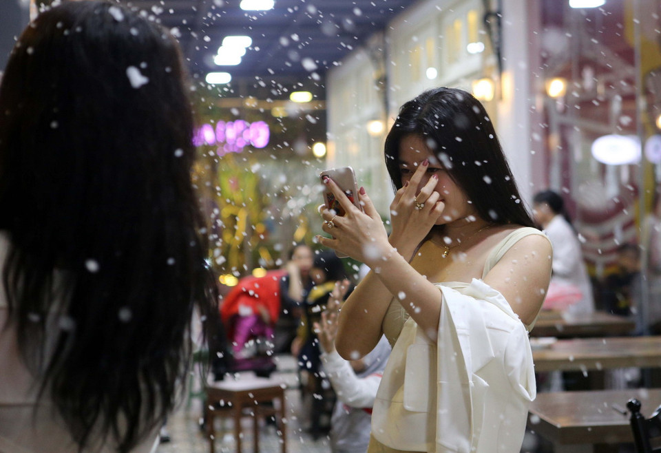 Tuyết rơi chậm rãi, lững thững bay giữa không gian dưới những ánh đèn đủ màu sắc càng trở nên lung linh, đẹp lạ mắt. (Ảnh: Trần Lê Lâm/Vietnam+)