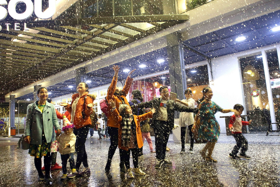 Trẻ em thích thú nô đùa với những cơn mưa tuyết nhân tạo. (Ảnh: Trần Lê Lâm/Vietnam+)