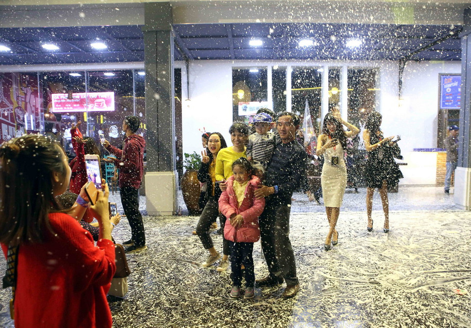 Các gia đình tranh thủ ghi lại khoảnh khắc tuyệt vời với tuyết rơi. (Ảnh: Trần Lê Lâm/Vietnam+)