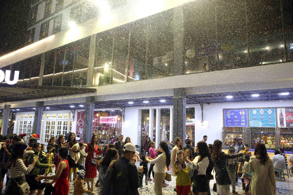 Những bọt tuyết trắng xóa được phun từ trên cao rơi chậm rãi tạo nên khu vườn tuyết tại Cocobay Đà Nẵng thu hút đông đảo người dân đến vui chơi thưởng lãm. (Ảnh: Trần Lê Lâm/Vietnam+)