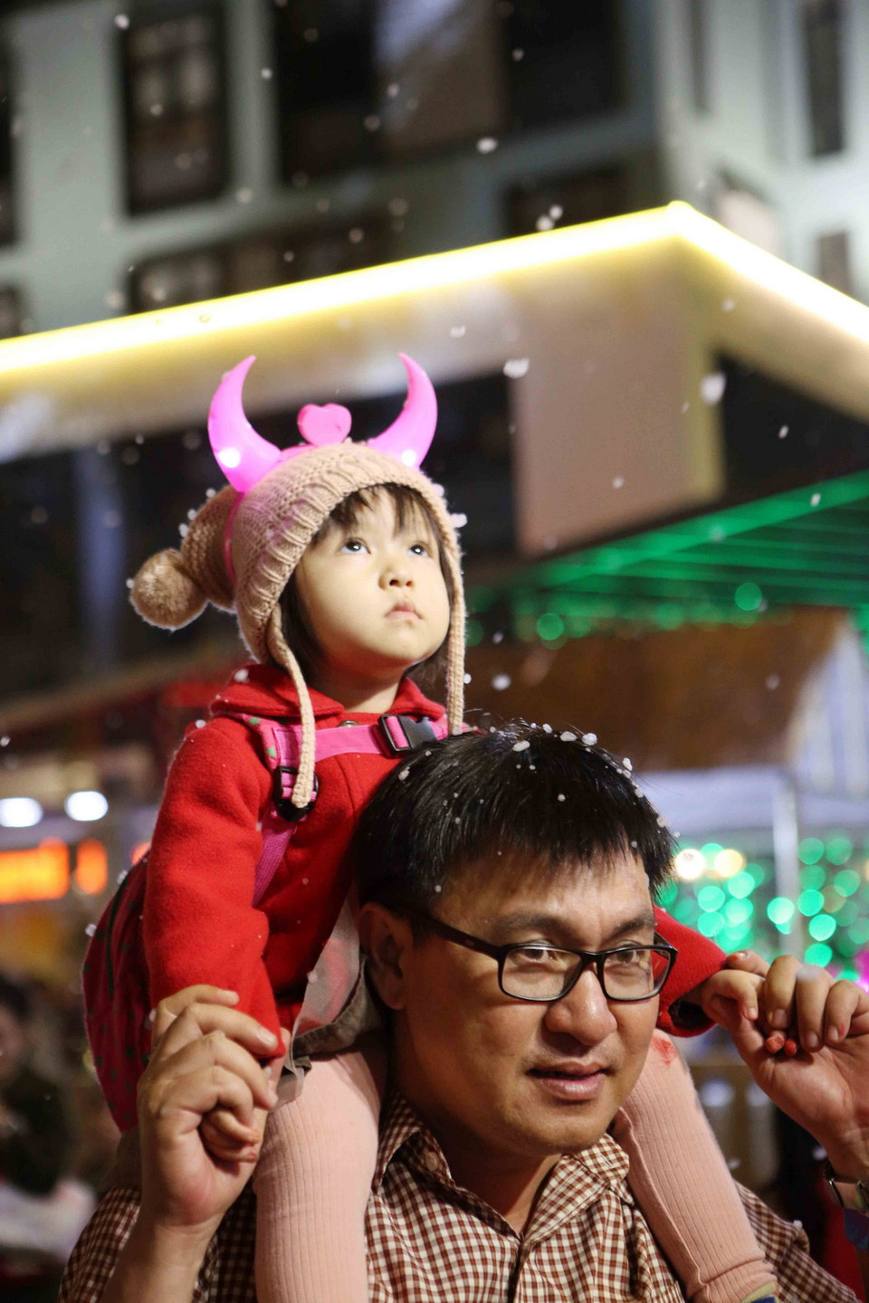 Cha cõng con gái trên vai để có thể nhìn rõ hơn những bông tuyết trắng. (Ảnh: Trần Lê Lâm/Vietnam+)