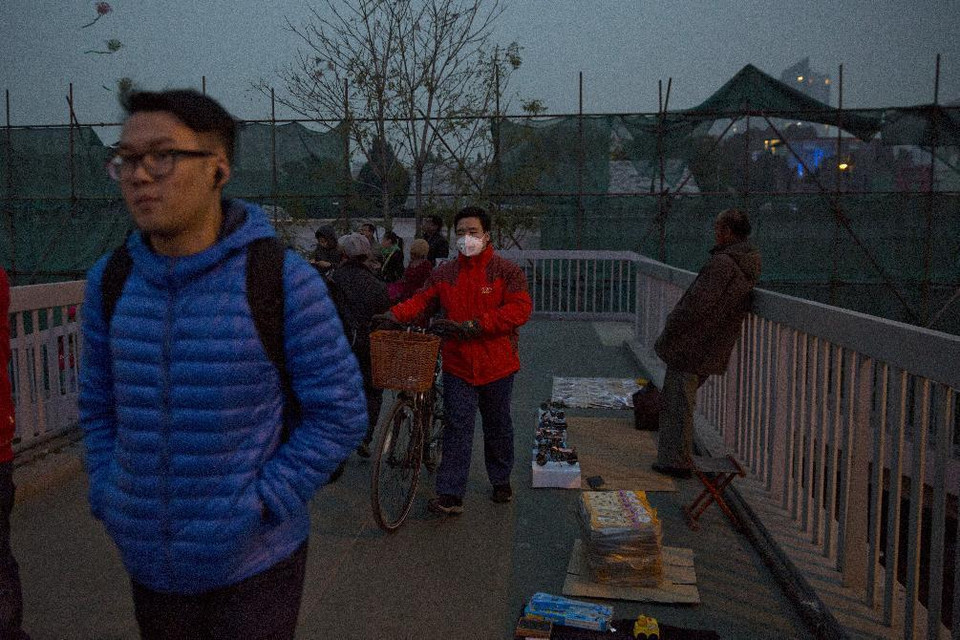 Một thanh niên đeo khẩu trang bảo vệ sức khỏe khỏi khói bụi ô nhiễm ở Bắc Kinh. (Nguồn: AP)