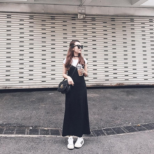 Cũng chọn vòng cổ choker làm phụ kiện nhấn, Yến Trang nổi bật với phong cách tối giản được biến tấu mang đầy cảm hứng mới mẻ. Cô kết hợp áo phông trắng và đầm đen, 'mix' cùng giày thể thao và túi đeo chéo.