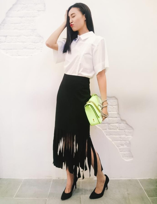 Ninh Dương Lan Ngọc 'mix' ngẫu hứng sơ mi trắng và chân váy tua rua phảng phất tinh thần boho (du mục). Nữ diễn viên tài năng chọn túi xách màu neon của Christian Louboutin tạo nét chấm phá.