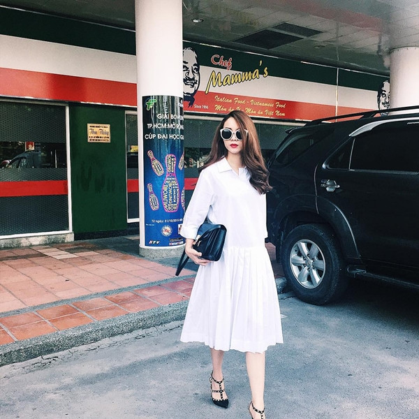 Đầm sơmi cũng là item được Yến Trang 'sủng ái.' Cô phối thiết kế đầm trắng tinh khôi cùng giày cao gót nạm đinh của Valentino, tôn phần duyên dáng. 