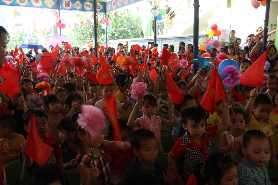 Ở phía dưới các bạn học sinh phất cờ cổ vũ rất nhiệt tình. (Ảnh: Tiến Đạt/Vietnam+)