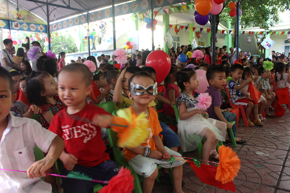 Đa số em bé đều rất kiên nhẫn chờ đợi lễ khai giảng bắt đầu. (Ảnh: Tiến Đạt/Vietnam+)