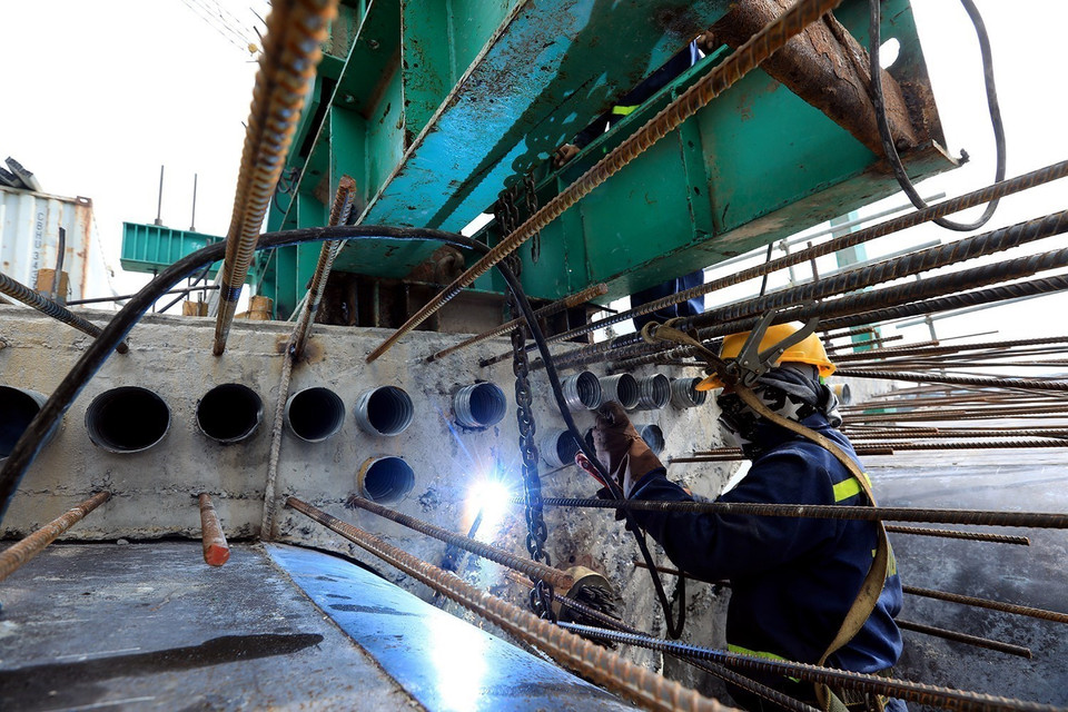 Công nhân hàn giữ treo khuôn trên trụ cầu 21. (Ảnh: Tuấn Anh/TTXVN)