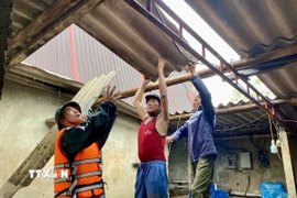 Lực lượng vũ trang hỗ trợ người dân xã Thiên Cầm dọn dẹp nhà cửa hư hỏng do bão. (Ảnh: Hữu Quyết/TTXVN)