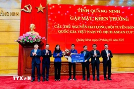 Bí thư Tỉnh ủy Vũ Đại Thắng và lãnh đạo tỉnh Quảng Ninh tặng hoa, tiền thưởng 350 triệu đồng cho cầu thủ Nguyễn Hai Long (từ nguồn ngân sách địa phương và xã hội hóa). (Ảnh: Thanh Tùng/TTXVN phát)