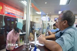 Cán bộ Bảo hiểm tỉnh Thái Bình tiếp người dân đến giải quyết thủ tục liên quan đến bảo hiểm. (Ảnh: Vũ Quang/TTXVN)