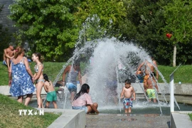 Người dân tránh nóng bên đài phun nước tại Madrid, Tây Ban Nha. (Ảnh: THX/TTXVN)