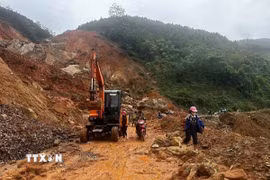 Lực lượng chức năng đã đưa máy móc đến khắc phục các điểm sạt lở trên tuyến tỉnh lộ 160, huyện Bắc Hà, Lào Cai. (Ảnh: TTXVN phát)