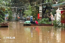 Người dân phải dùng thuyền để làm phương tiện di chuyển trong những ngày mưa lũ. (Ảnh: Việt Hoàng/TTXVN)