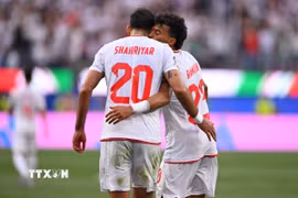 Ramin Rezaeian (số 23) ăn mừng sau khi ghi bàn thắng gỡ hòa 1-1 cho Iran. (Ảnh: AFP/TTXVN)