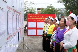 Cử tri thôn Đồng Quân, xã Cúc Phương tìm hiểu về danh sách và tiểu sử những người ứng cử để gửi gắm niềm tin nơi lá phiếu. (Ảnh: Đức Phương/TTXVN)