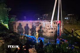 Lực lượng chức năng làm nhiệm vụ tại hiện trường tai nạn lật xe khách ở xã Phước Thành, huyện Tuy Phước (Bình Định). (Ảnh: TTXVN phát)