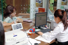 Khách hàng giao dịch tại Hội sở Vietcombank ở Hà Nội. (Ảnh: Trần Việt/TTXVN)