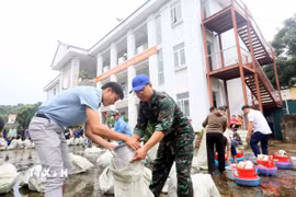Sắp xếp đồ dùng, vật dụng sinh hoạt hàng ngày để trao cho các hộ dân bị thiệt hại, ảnh hưởng do thiên tai, mưa lũ. (Ảnh: Quang Quyết/TTXVN)