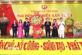 Bí thư Trung ương Đảng, Trưởng Ban Chính sách, chiến lược Trung ương Trần Lưu Quang tặng hoa chúc mừng Đại hội. (Ảnh: Đinh Thùy/TTXVN)