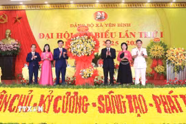 Bí thư Trung ương Đảng, Trưởng Ban Chính sách, chiến lược Trung ương Trần Lưu Quang tặng hoa chúc mừng Đại hội. (Ảnh: Đinh Thùy/TTXVN)