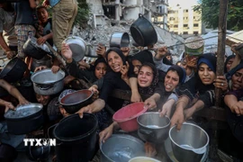 Người dân Palestine chờ được phát thực phẩm cứu trợ tại Gaza. (Ảnh: THX/TTXVN)