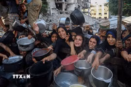 Người dân Palestine chờ được phát thực phẩm cứu trợ tại Gaza. (Ảnh: THX/TTXVN)
