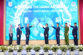 Phó Thủ tướng Hồ Quốc Dũng và các đại biểu thực hiện nghi thức bấm nút triển khai nền tảng số về Thi hành án dân sự. (Ảnh: Phạm Kiên/TTXVN)
