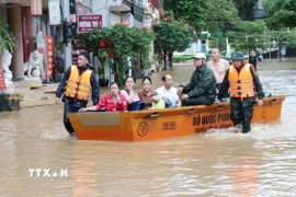 Bộ đội biên phòng giúp sơ tán người dân đến nơi an toàn. (Ảnh: Đức Thọ/TTXVN)