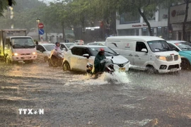 Trên tuyến phố Nguyễn Văn Cừ, Long Biên ngập úng diện rộng gây ảnh hưởng đến các phương tiện tham gia giao thông. (Ảnh: An Đăng/TTXVN)