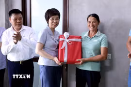 Tổng Giám đốc TTXVN Vũ Việt Trang tặng quà cho gia đình được TTXVN hỗ trợ xây dựng nhà mới. (Ảnh: Quang Cường/TTXVN)