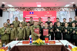 Ban Chỉ huy Bộ đội Biên phòng tỉnh Quảng Trị và Công an tỉnh Salavan (Lào) ký biên bản Hội đàm. (Ảnh: TTXVN phát)