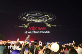 Người dân tập trung đông đúc tại khu vực Bến Bạch Đằng (Quận 1) để chiêm ngưỡng màn trình diễn drone đặc sắc. (Ảnh: Thu Hương/TTXVN)