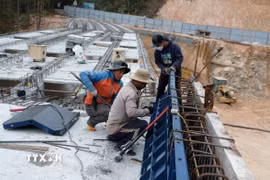 Công nhân thi công để chuẩn bị đổ bêtông phần thành cầu cạn bắc qua điểm sạt lở trên đèo Mimosa Đà Lạt. (Ảnh: Nguyễn Dũng/TTXVN)