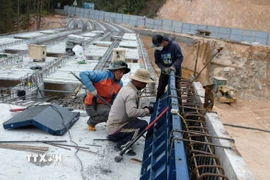 Công nhân thi công để chuẩn bị đổ bêtông phần thành cầu cạn bắc qua điểm sạt lở trên đèo Mimosa Đà Lạt. (Ảnh: Nguyễn Dũng/TTXVN)