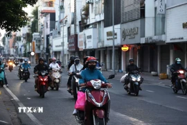 Người dân trong trang phục giữ ấm đi làm trên đường Hồ Văn Huê (phường Đức Nhuận) thời điểm 6 giờ 20 phút sáng 9/1/2026. (Ảnh: Hồng Đạt/TTXVN)