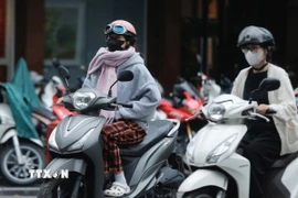 Người dân mặc áo ấm khi ra đường. (Ảnh minh họa: Minh Quyết/TTXVN)